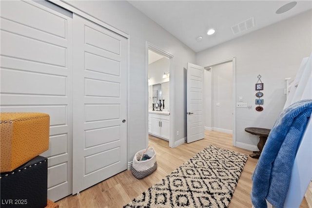 bedroom featuring visible vents, baseboards, recessed lighting, light wood-style flooring, and ensuite bath
