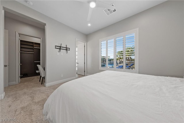 bedroom with ceiling fan, visible vents, baseboards, carpet floors, and a spacious closet