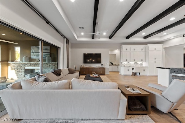 living area featuring visible vents, beam ceiling, ceiling fan, recessed lighting, and light wood-type flooring