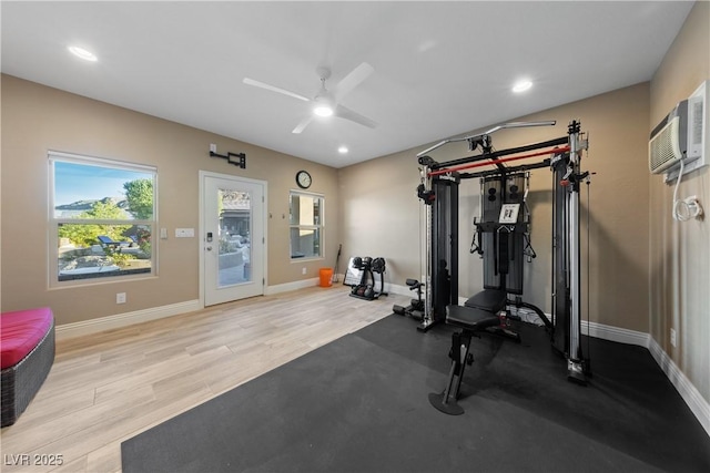 exercise area with baseboards, a ceiling fan, wood finished floors, and a wealth of natural light