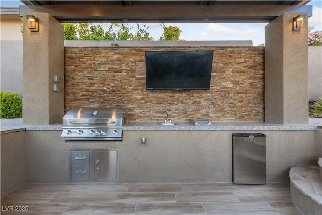 view of patio / terrace with exterior kitchen and a grill