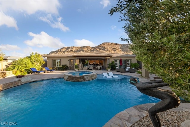 view of swimming pool featuring an outdoor living space, a mountain view, a pool with connected hot tub, and a patio