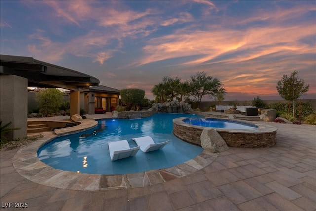 view of pool with a patio and a pool with connected hot tub