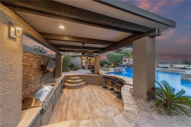 patio terrace at dusk featuring a hot tub, area for grilling, an outdoor pool, a ceiling fan, and a grill