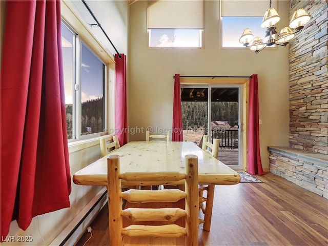 dining space featuring a notable chandelier, a healthy amount of sunlight, and wood finished floors