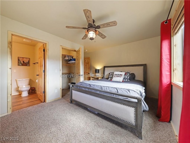 bedroom featuring connected bathroom, a walk in closet, carpet floors, baseboards, and a closet