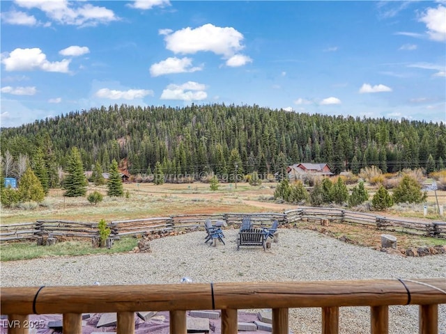 view of yard featuring fence and a forest view