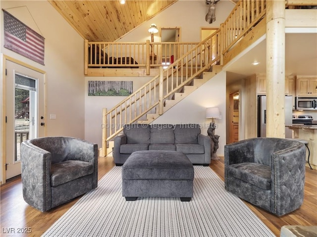 living room featuring stairway, wood finished floors, high vaulted ceiling, and wooden ceiling