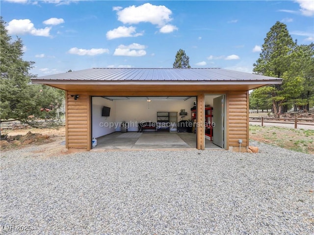 view of car parking with a garage and fence