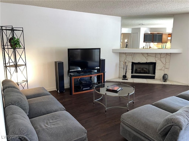 living area with a textured ceiling, wood finished floors, and a fireplace