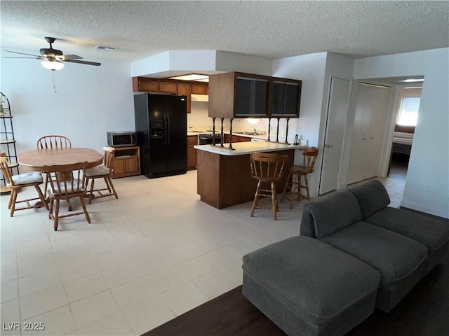 living area featuring ceiling fan and a textured ceiling