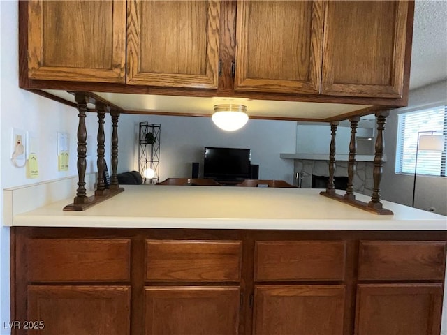 interior space featuring light countertops, a peninsula, and brown cabinets