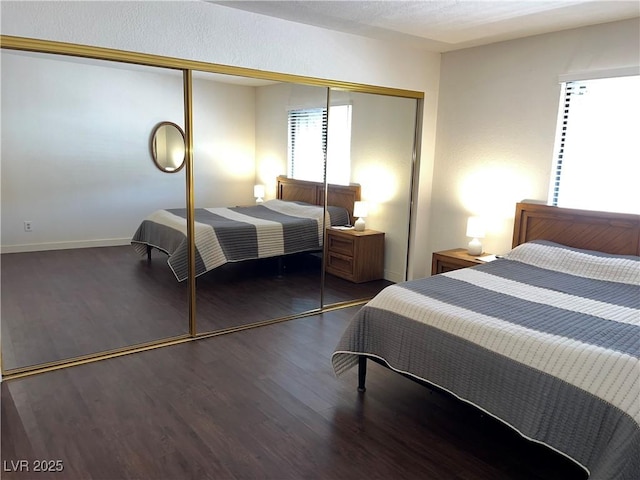 bedroom featuring baseboards, a closet, and wood finished floors