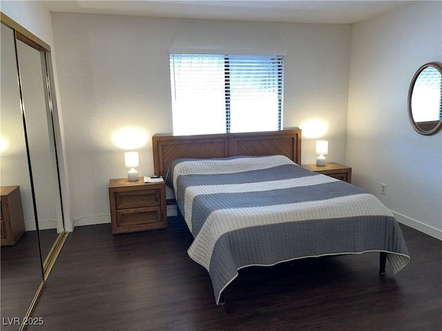 bedroom featuring baseboards, dark wood-style flooring, and a closet