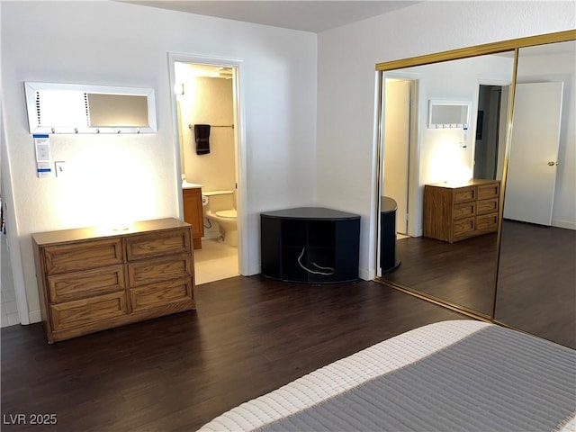 bedroom with connected bathroom, a closet, and dark wood-type flooring