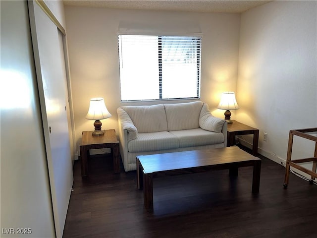 living area featuring baseboards and wood finished floors