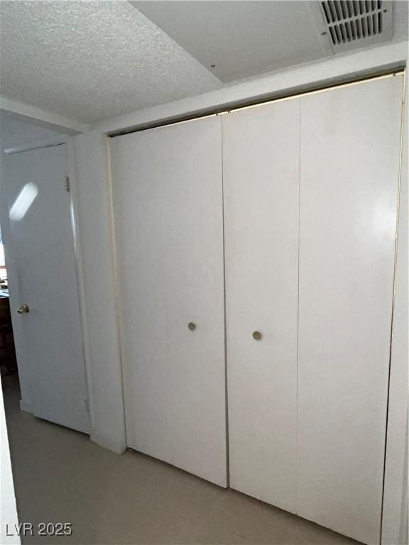 basement with a textured ceiling and visible vents