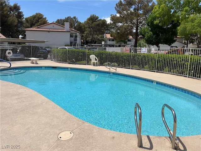 pool with a patio and fence