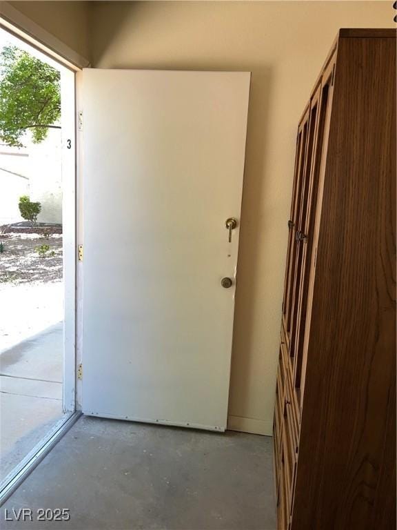 doorway with unfinished concrete floors