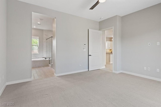 unfurnished bedroom featuring carpet floors, a ceiling fan, baseboards, and connected bathroom