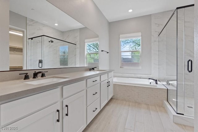 bathroom with a garden tub, a sink, and a stall shower