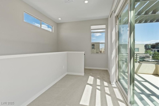carpeted empty room featuring baseboards and recessed lighting