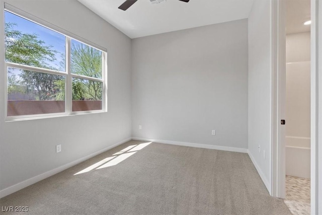 empty room featuring baseboards, ceiling fan, and carpet