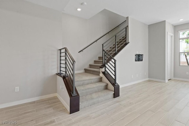 staircase with recessed lighting, baseboards, and wood finished floors