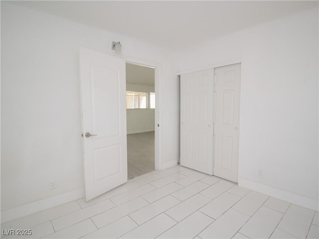 unfurnished bedroom featuring baseboards and a closet