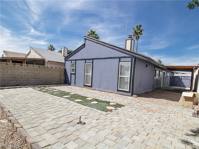 back of house with a patio, a chimney, and a fenced backyard