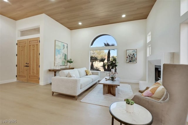 living area featuring recessed lighting, baseboards, wood ceiling, and light wood-style floors