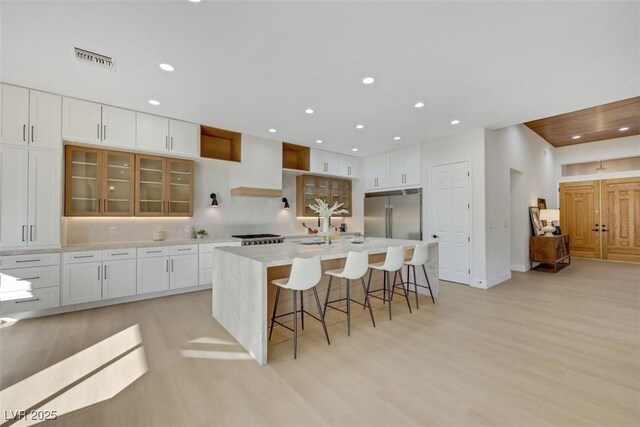 kitchen with recessed lighting, visible vents, stainless steel built in fridge, and light wood-type flooring