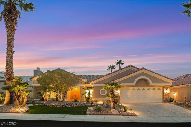single story home featuring a tile roof, an attached garage, driveway, and stucco siding