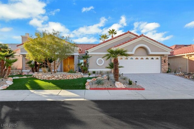 mediterranean / spanish home featuring an attached garage, decorative driveway, stucco siding, and a tiled roof