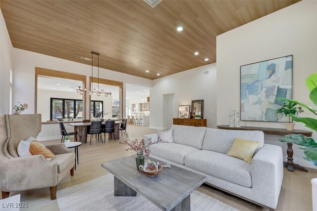 living room featuring wood ceiling, light wood finished floors, recessed lighting, and a notable chandelier