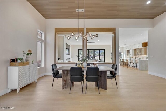 dining room featuring an inviting chandelier, baseboards, light wood finished floors, and visible vents