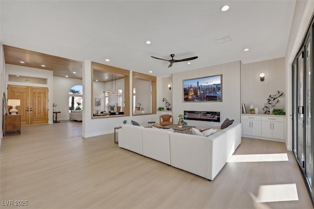 living room featuring ceiling fan, light wood-style floors, recessed lighting, baseboards, and visible vents