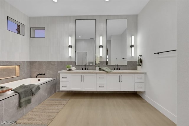 bathroom with a sink, a bath, and wood finished floors
