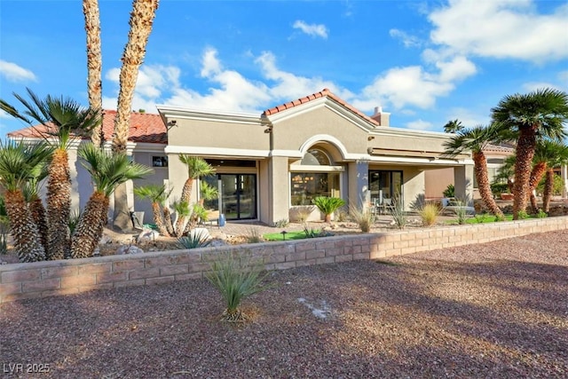mediterranean / spanish home with stucco siding and a tile roof