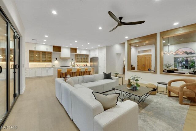 living room with recessed lighting, a ceiling fan, and light wood-type flooring
