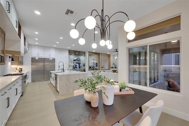 dining room featuring recessed lighting, a notable chandelier, visible vents, and light wood-type flooring
