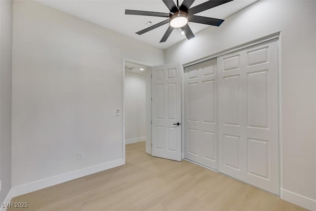 unfurnished bedroom with baseboards, light wood finished floors, ceiling fan, and a closet