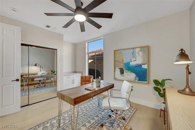 office with a ceiling fan, baseboards, and light wood-style floors