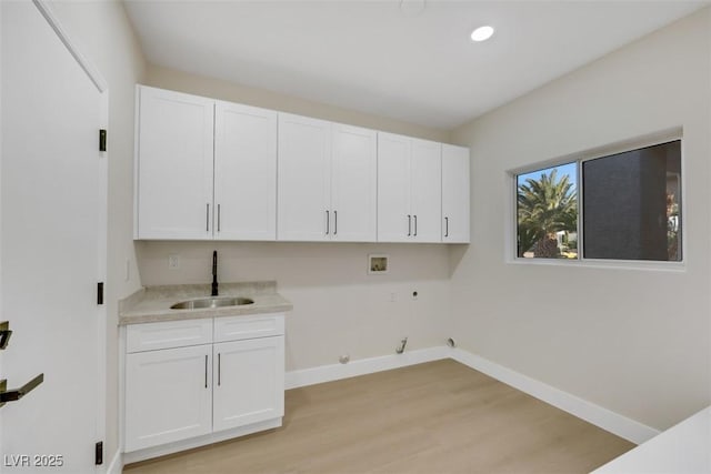 washroom featuring hookup for a washing machine, gas dryer hookup, a sink, cabinet space, and light wood finished floors