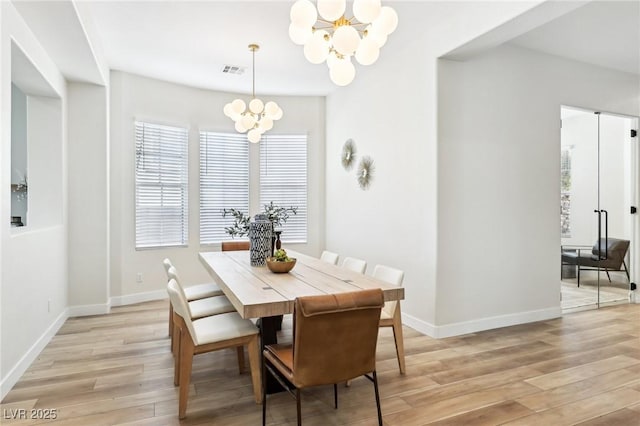 dining room featuring an inviting chandelier, baseboards, light wood-style flooring, and visible vents