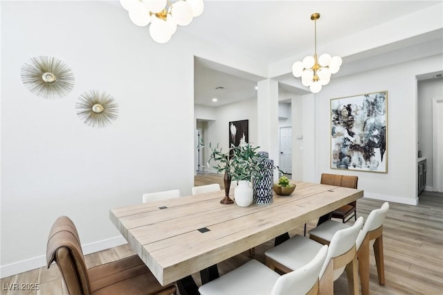 dining area with light wood-style floors, baseboards, recessed lighting, and a chandelier