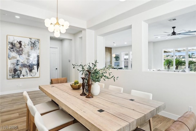 dining room featuring baseboards, a notable chandelier, light wood-style flooring, and visible vents