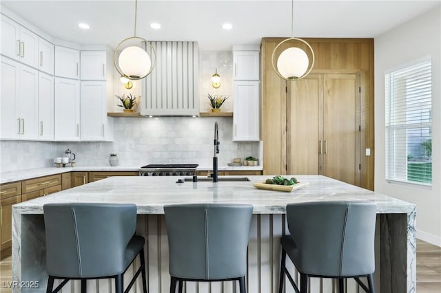 kitchen featuring open shelves, a sink, backsplash, and white cabinets