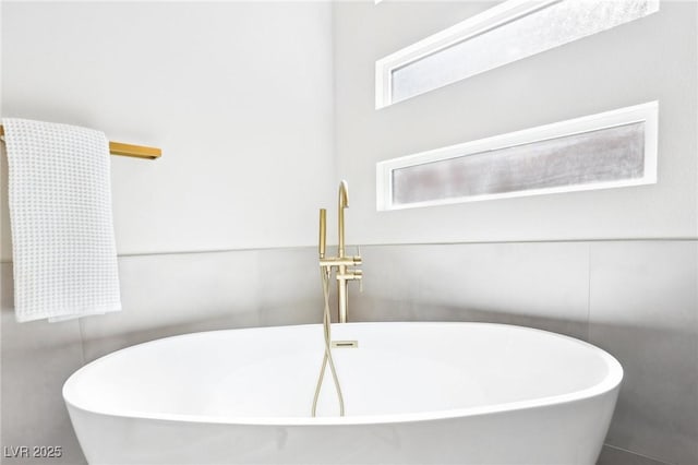 full bathroom with a freestanding bath and a sink