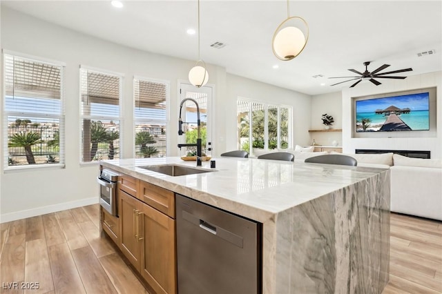 kitchen featuring a sink, stainless steel appliances, light wood-type flooring, and visible vents